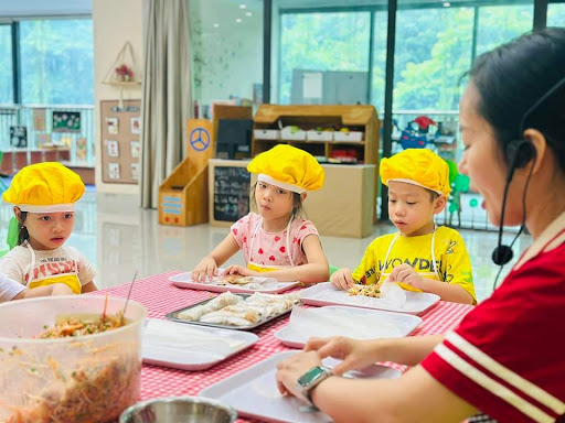 Bé hào hứng trong tiết học nấu ăn cùng cô giáo