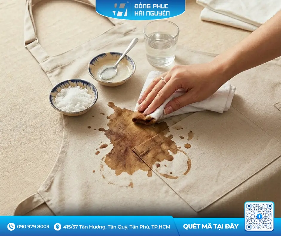 Dùng hỗn hợp muối và nước ấm xử lý vết cà phê trên tạp dề quán cafe màu be
