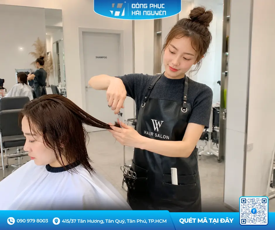 Thợ cắt tóc chuyên nghiệp sử dụng tạp dề nhựa màu đen chống thấm nước và hóa chất nhuộm tại salon.